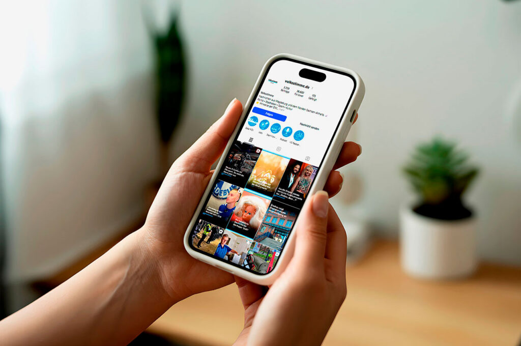 Eine Person hält ein Smartphone mit einer Social‑Media‑Profilseite