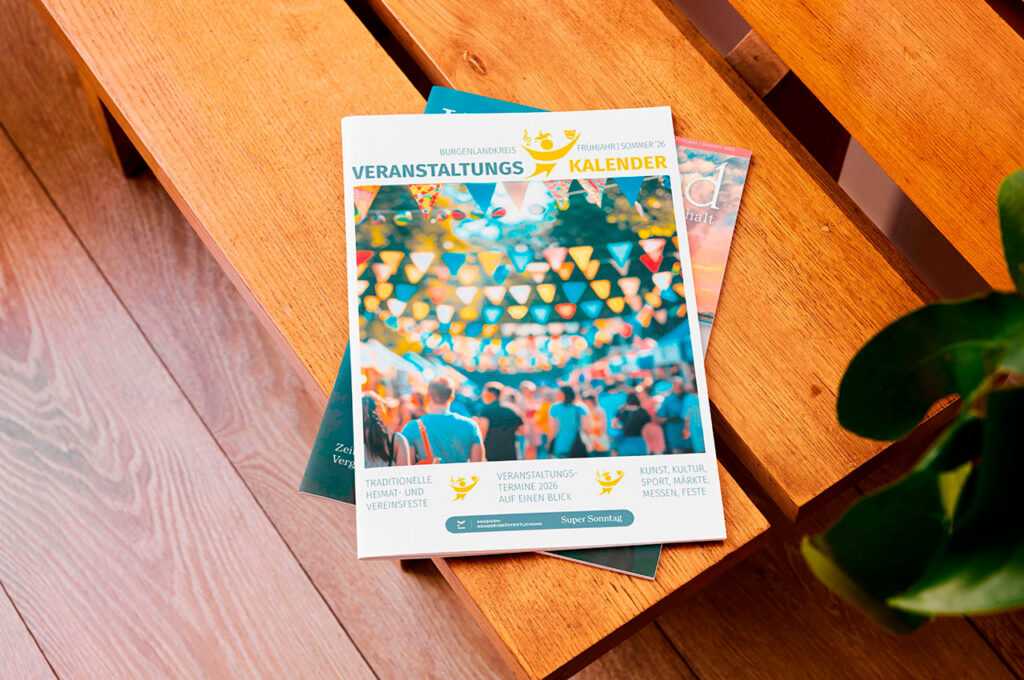 Das Magazin Veranstaltungs Kalender liegt auf einer Holzbank.