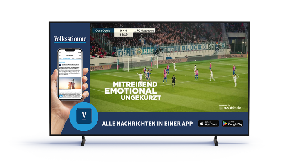 Advertisement on a flat-screen TV promoting the Volkstimme app, showing a hand holding a smartphone and app-store badges beside a soccer match.