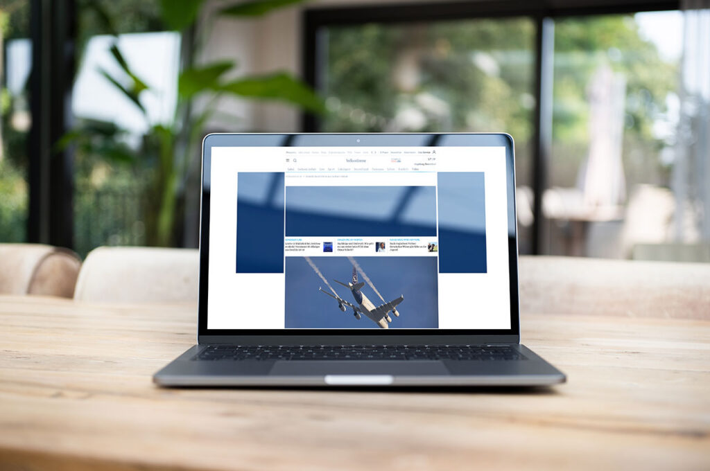 Laptop auf einem Holztisch mit geöffneter Nachrichtenwebsite. Im Hintergrund sind große Fenster und Zimmerpflanzen in einem hellen Innenraum zu sehen. ©Mockup AdobeStock, Inhalt Mediengruppe Mitteldeutschland
