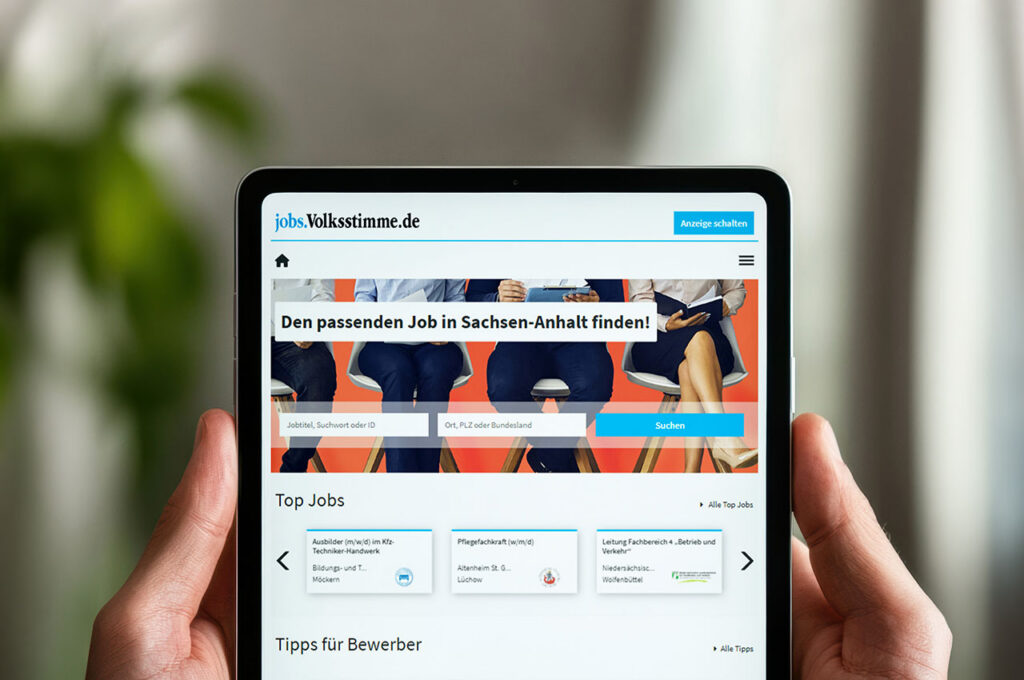Tablet mit geöffneter Jobbörse in den Händen einer Person. Auf dem Bildschirm sind Stellenangebote, eine Jobsuche und Informationen für Bewerber zu sehen. ©Mockup AdobeStock, Inhalt Mediengruppe Mitteldeutschland